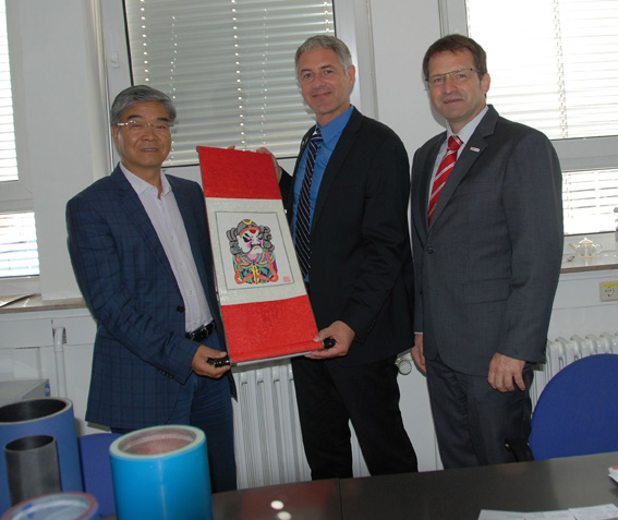 Professor Xu Wencai, Vice President Beijing Institute, presented a Chinese scroll painting to Dr Uwe Stebani, Vice President Technology, and Thomas Leuschner, Technical Representative, Flint Group Flexographic Products (from left to right)